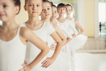 group of little caucasian ballerinas stand in a row and practice ballet together. pretty amazing...
