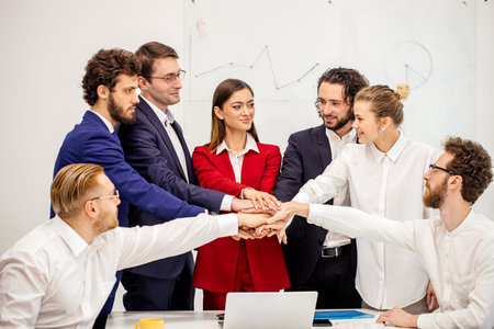 close-knit friendly business team joined hands in one, before launch of joint project, everyone in...
