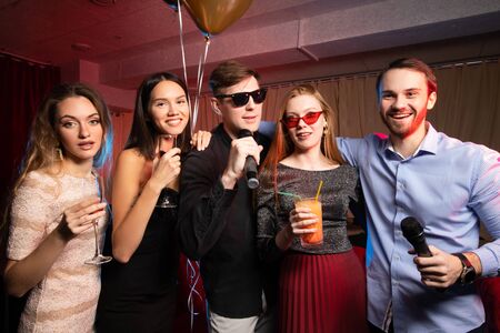 fun and entertainment concept. group of young people spend free time in karaoke, sing and have fun together, with friendsの写真素材
