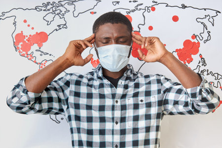 portrait of sick black african guy having headache and fever during coronavirus pandemic. protect...