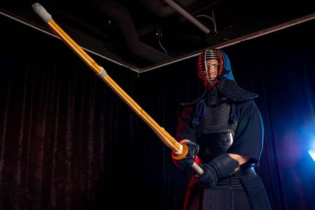 portrait of caucasian strong man kendo fighter with bokuto. kendo warrior male holding samurai sword katanaの写真素材