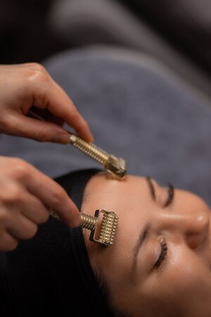 professional masseur use derma roller for lifting face care, clients came in luxury spa salon to get wellness beauty procedures, take care of skinの写真素材