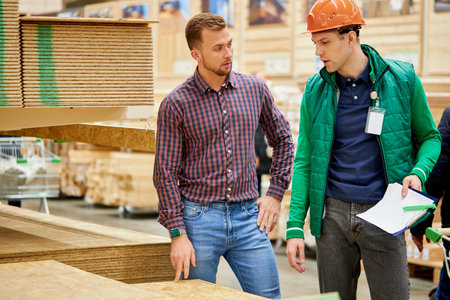 warehouse worker show the best variant of wooden board in their market, customer looking for...