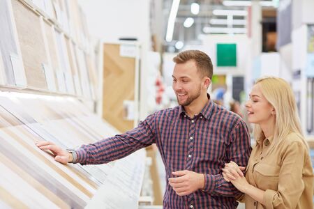 young caucasian couple looking for the most suitable commodity in the market, man touch commodity, want to buyの写真素材