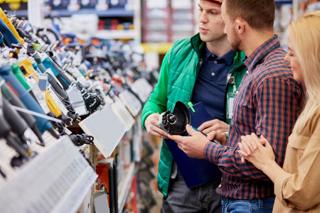 young caucasian man represents working well equipment for customer, customer attentively listen to...