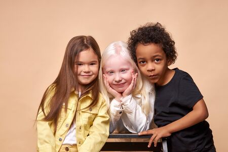happy smiling kids isolated in studio, albino,afro american and european children laugh, smile at camera, wearing bright clothes. children diversity, kindness, tolerance conceptの写真素材