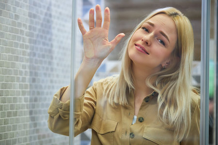 young caucasian beautiful womans face crushed on transparent glass, she want this product in the...
