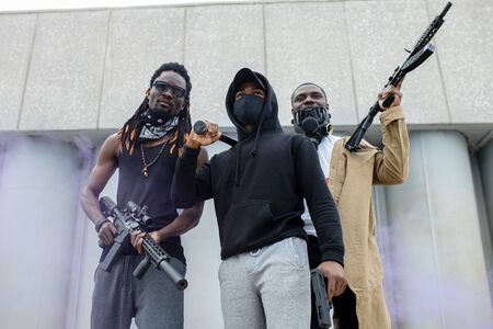 three black men with guns ready to shoot if discrimination does not stop, they are dissatisfied with the attitude of white people to themの写真素材