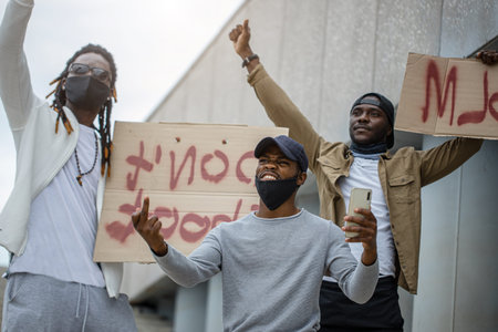Black lives matter protests go global. three afroamerican people with posters in the street, black...