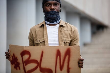 black man protest against injustice, blm concept. young guy in t-shirt with BLM inscription. George Floyd protest. human rights, racism, justice conceptの写真素材