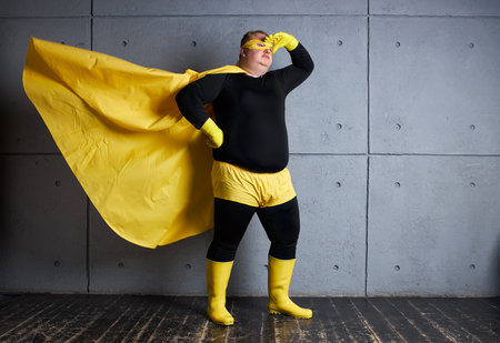 superhero fat man loking for danger and problems that he can solve, looks side. isolated gray...