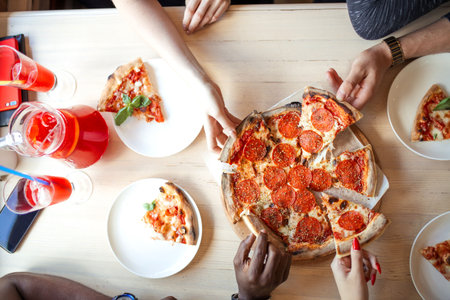 Summer dinner or lunch at street cafe indoor. Flat-lay of people hands taking freshly baked Italian...