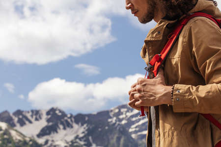 Man Traveler with yellow parka and red backpack hiking outdoor. Travel, Lifestyle, vacation and Adventure conceptの写真素材