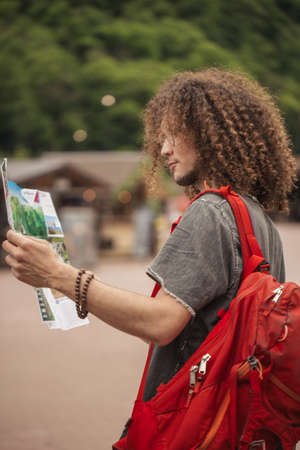 Young tourist with route maps looking for a way in city. search landmarksの写真素材