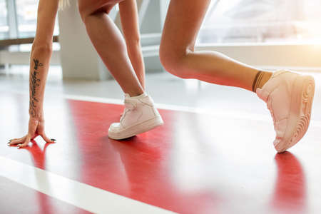 sport blond woman wearing sportswear prepared to run. low start poseの写真素材