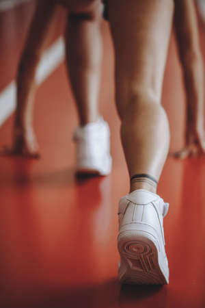 rear view close up sport woman legs wearing sportswear prepared to run. low start poseの写真素材