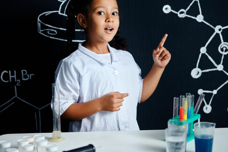 Little smart clever asian girl in white lab coat discovered something exciting in chemical...