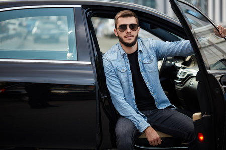 gorgeous driver sitting on the car and posing to the camera. closeup photo