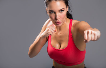 sweaty awesome slim girl training with clenched fists. preparation for the competition. close up...