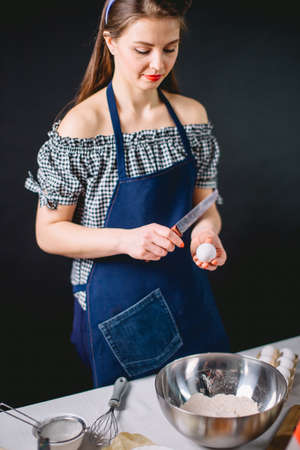 Confectioner breaking an egg to separate egg white and yolksの写真素材