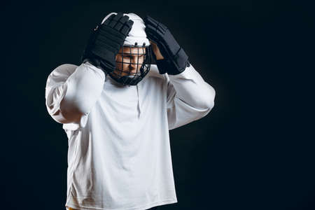Handsome hockey player ajusting his helmet on head asking the supporters if there is so any interest in going to that hockey gameの写真素材