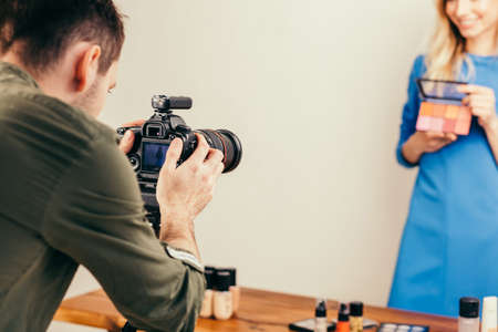 young man using the digiatl camera to take a photo of famous cosmetician. close up cropped photoの写真素材