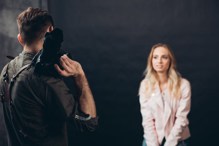 young talented photographer making up a pose for a good looking female client, creative shot, close...