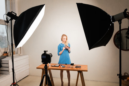 Pretty young woman showing healthy cosmetics for customers in the studio, beauty, body, health care,...