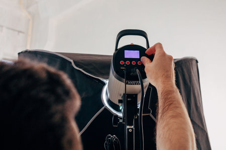 professional photographer turning on the lighting equipment before photo shoot, close up photo,...