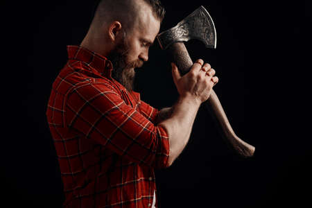 Serious lumberjack. Confident bearded man attached to forehead axeの写真素材