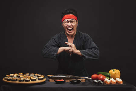 kung fu training while cooking. crazy mad man with funny grimace. close up photo.karate position. martial art concept. welcomeの写真素材