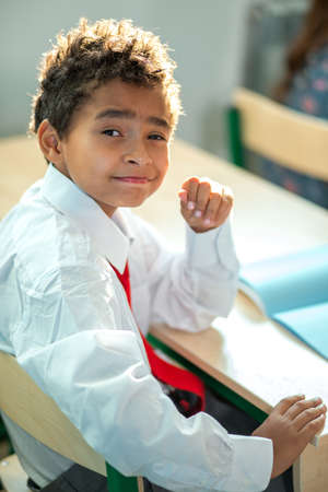 black school boy sittiing in classroom at deskの写真素材