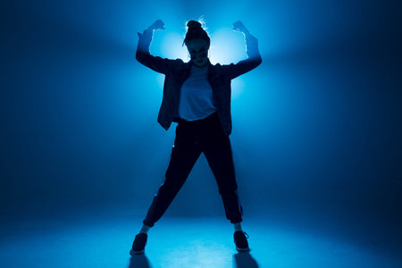 Stylish woman dancing solo on hip hop party. Sunglasses, modern black dance wear, neon lights.