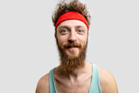 Cheerful man with red headband looking at camera.の写真素材