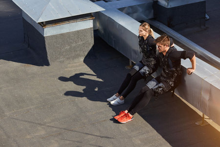 two athletes are performing knee bends. top view full length photo