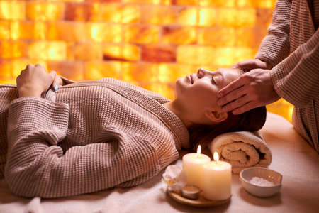 Attractive woman enjoy spending time in spa salon lying on bed in bathrobe and taking spa procedures. rest and comfort.の写真素材