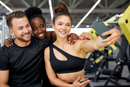 cheerful multiethnic sportive team take a break after crossfit, take photo on smartphone and smile
