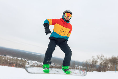 active guy is going to perform a jump at ski resort. full length photo, spare time, careless life,...
