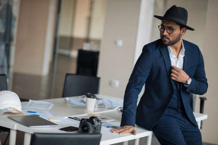 stylish actor is posing to the camera. close up photo. copy space. pensive fashion guy thinking about business indoorsの写真素材