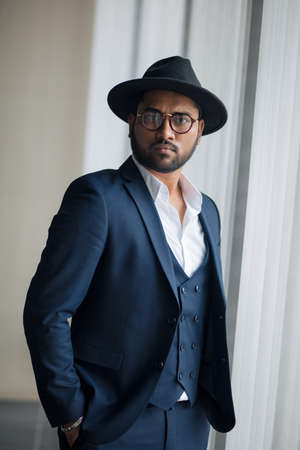 teddy guy. stunning celebrity in a hat standing with hands in the pockets . close up portrait.の写真素材