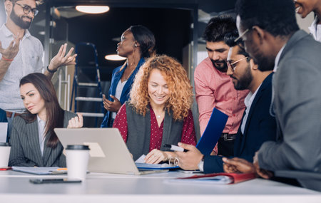 Searching of new insights and brilliant ideas. Mixed-race group of nine diverse people browsing net...
