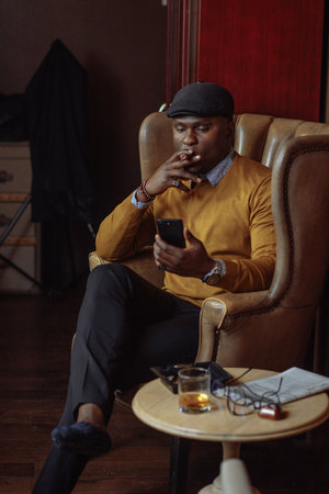 African american sales manager male in yellow coat and black hat waiting for his client in...