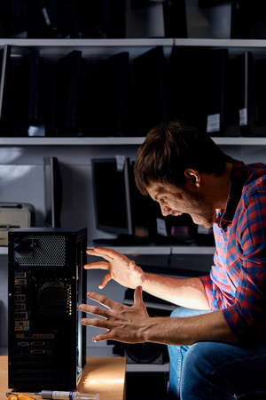 excited annoying repairment at workplace at night, close up side view photoの写真素材