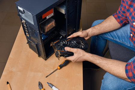 man is maintaining computer equipment, close up top view photo.