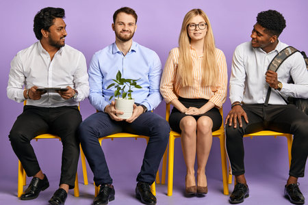 young people of different nationalities sitting in a row in friendly atmosphere isolated on purple...