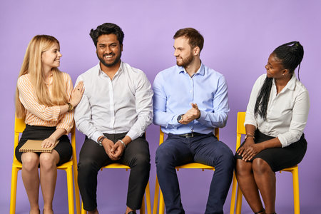 Multinational team smiling happily and congratulating their coworker and waiting for job interview