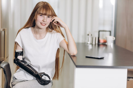 awesome girl with a cyber arm leaning on the table and looking at the camera, leisureの写真素材