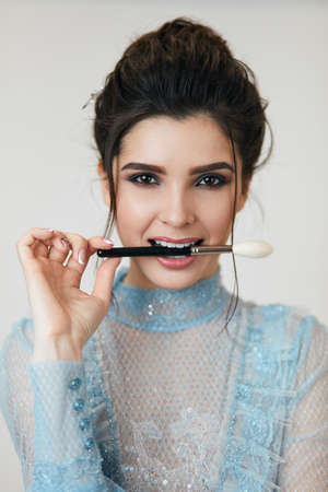 charming girl with brush in her mouth. close up photoの写真素材