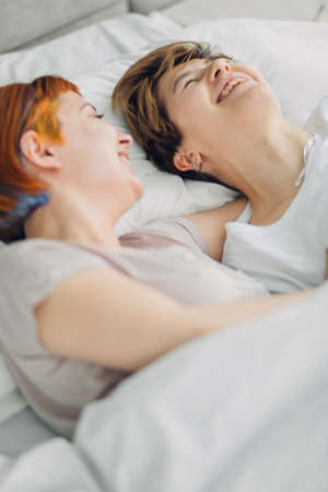 two crazy girls telling jokes to each other while having a rest. close up side view photoの写真素材