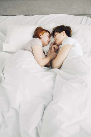 Beautiful women sleep in bed at home, sleeping time. two awesome girls relaxing on the bedの写真素材
